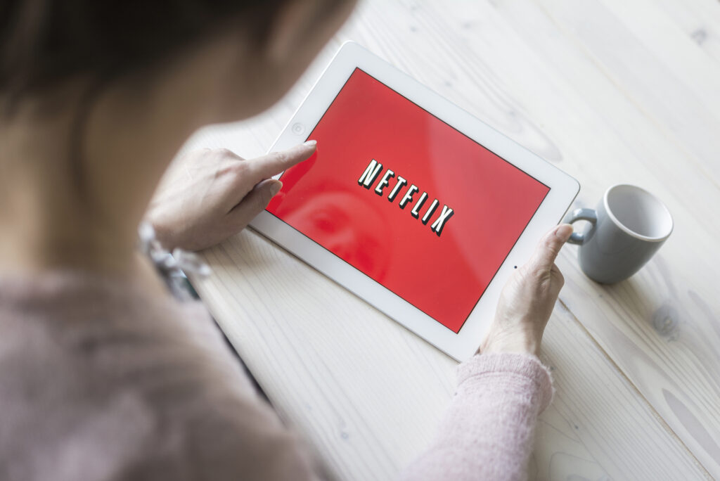 Person holding tablet showing netflix logo 