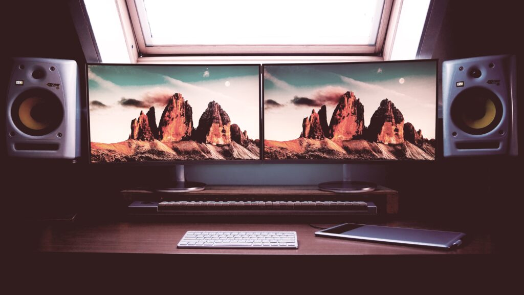 view of two dual screen monitors connected to speakers