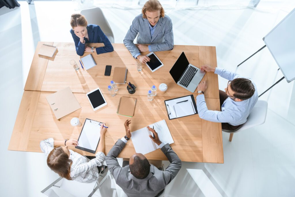 People in a meeting at work all working on tablets or laptops