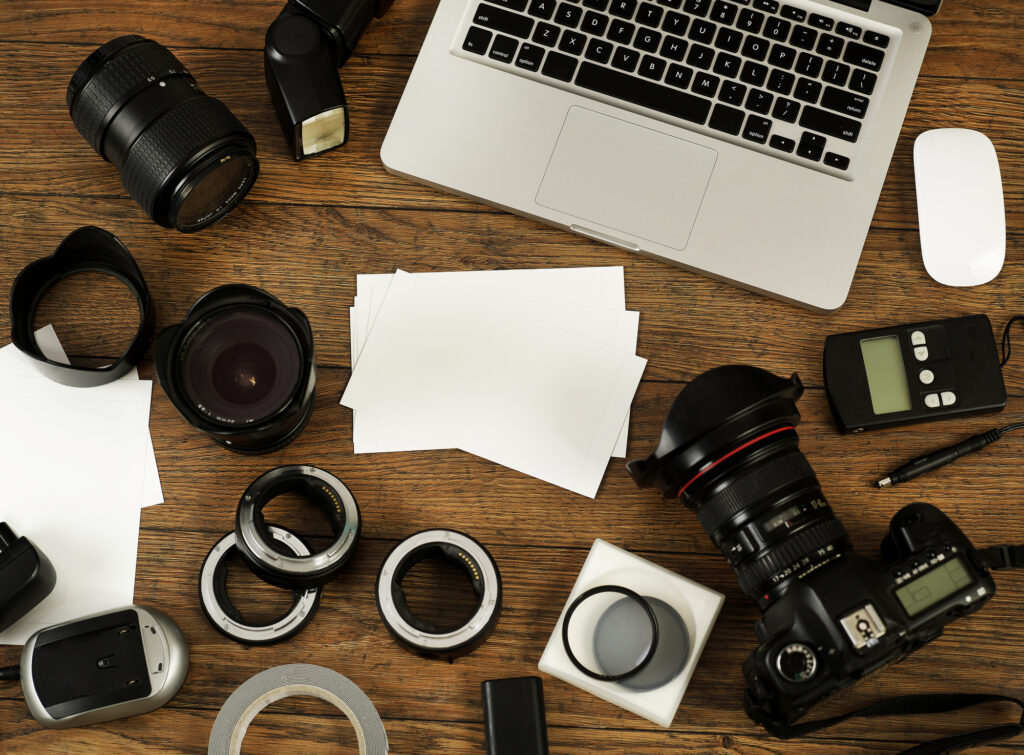 Laptop with camera gear scattered around it