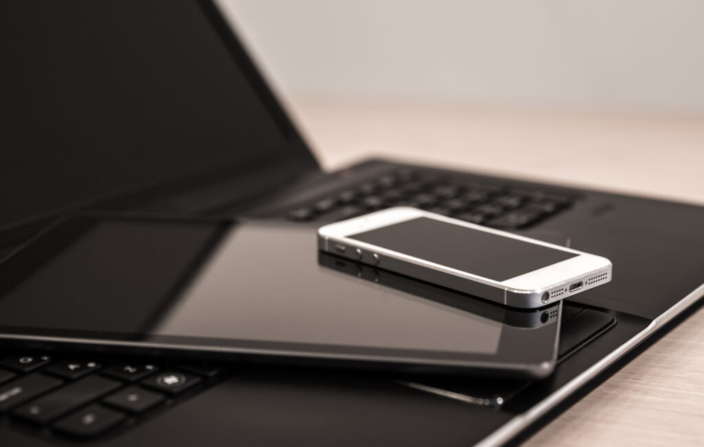 iphone, ipad, and laptop stacked on top of each other