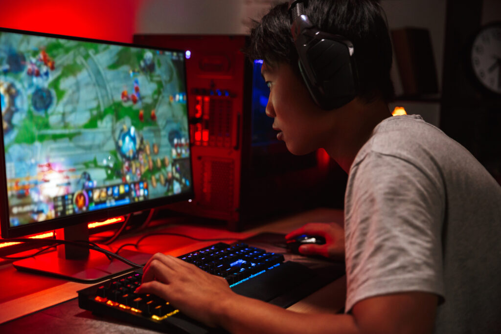 Guy playing video game on PC set up