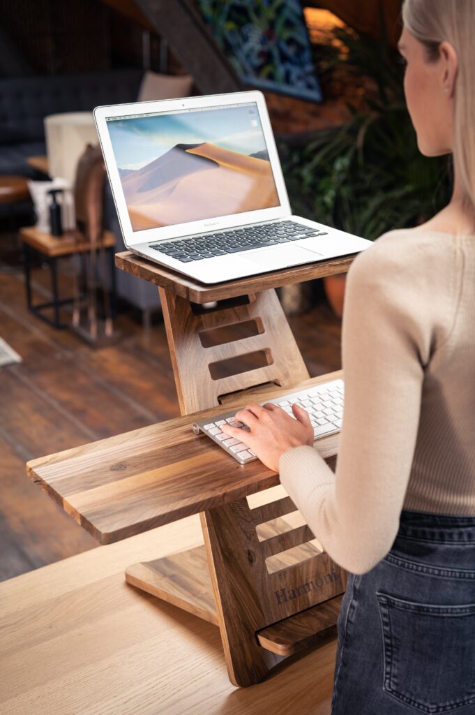 woman typing at an ergonomic desk stand