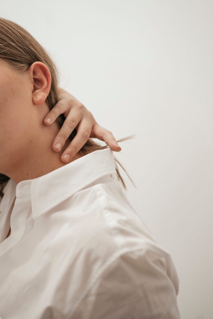 women touching the back of her neck