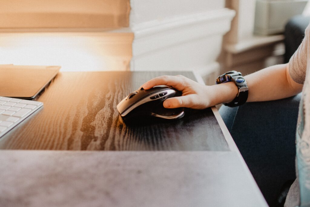 person with hand on ergonomic mouse for computer