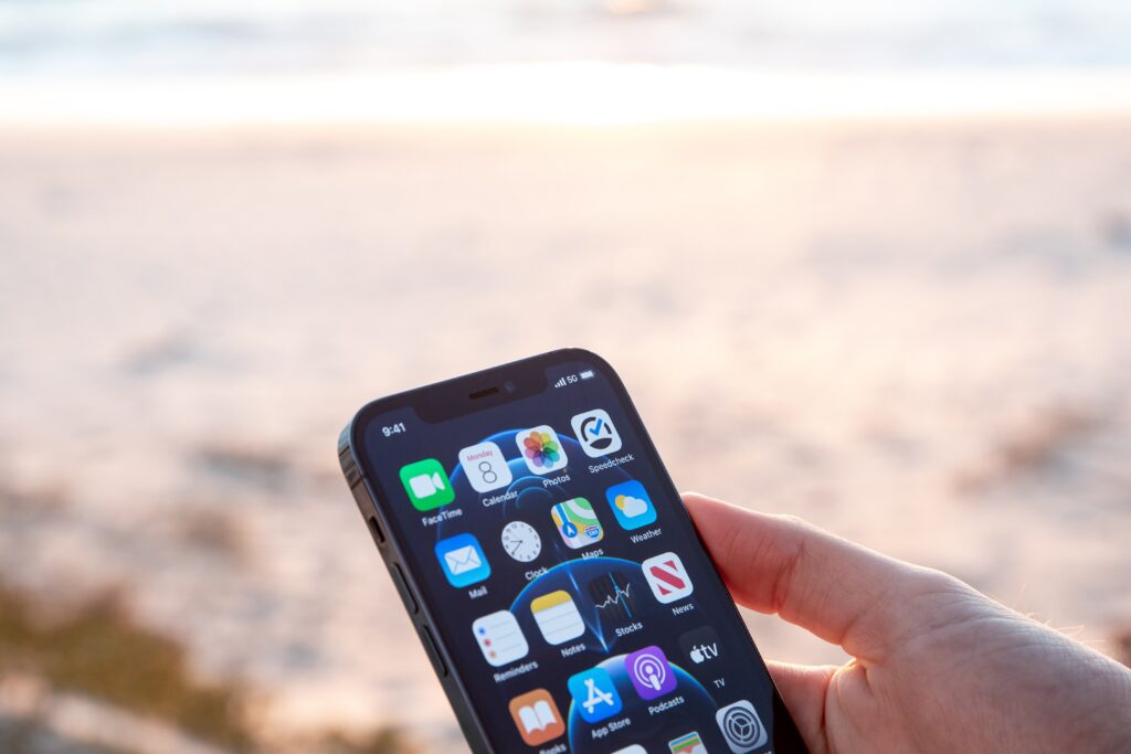 person at the beach holding their iphone 