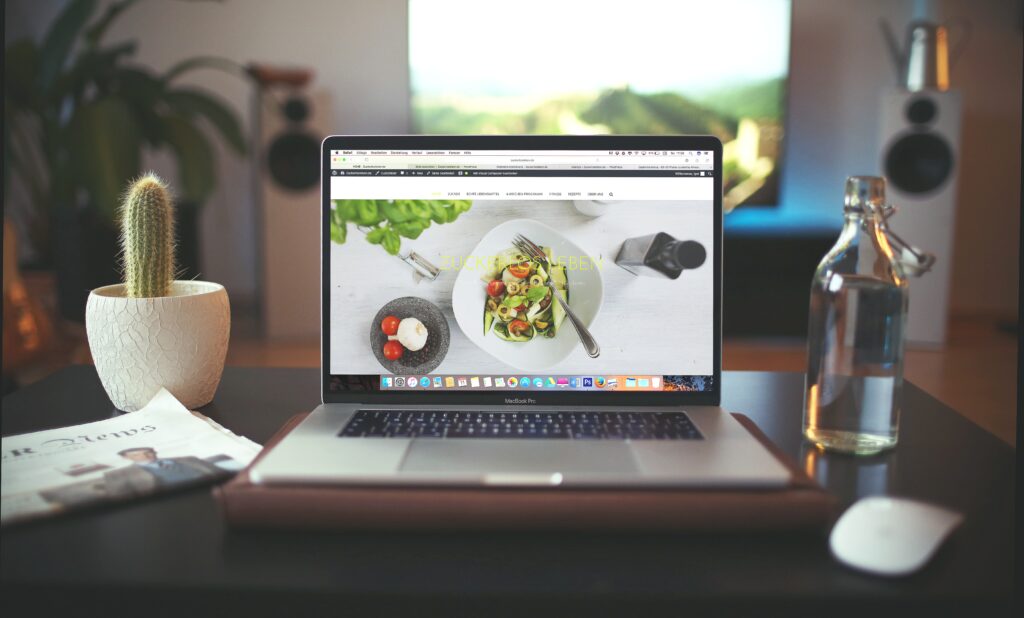 laptop sitting on desk with food blog website being displayed