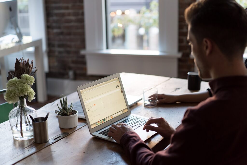 person sitting at dining room table working on laptop