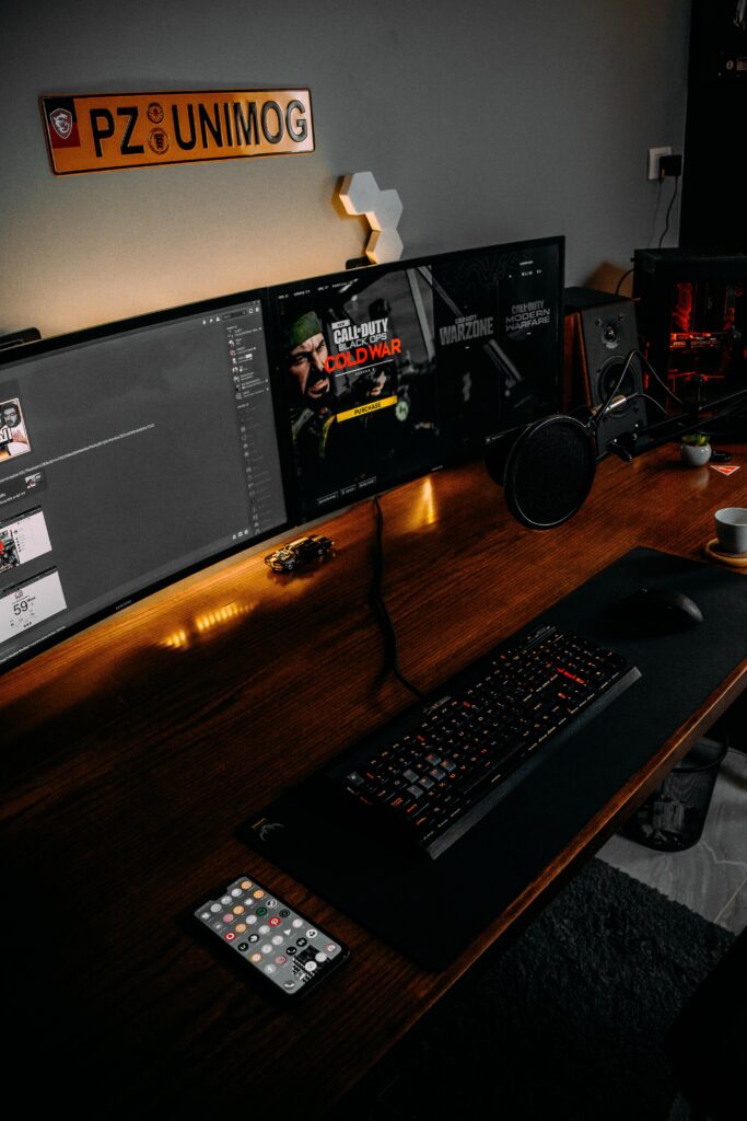 View of desk with a full gaming setup and multiple gaming monitors.