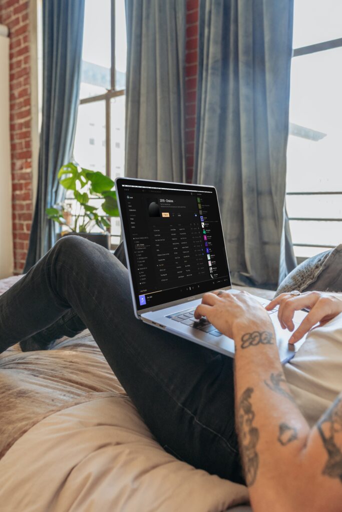 man sitting on couch working on laptop