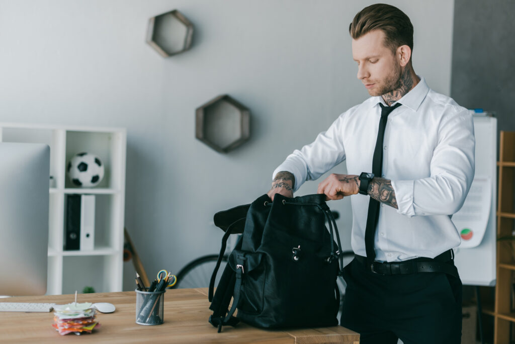 businessman putting his laptop away in his backpack