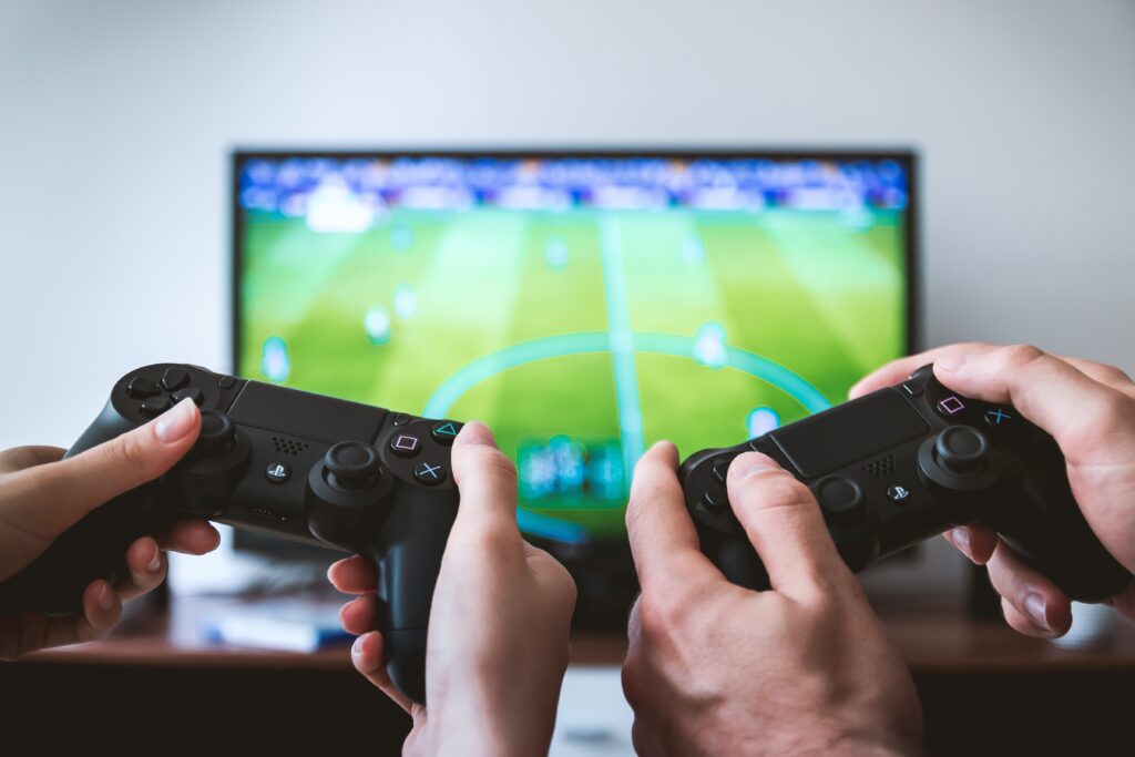 two people holding controllers playing a video game on a screen