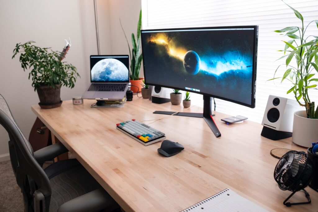 curved monitor sitting on desk next to laptop