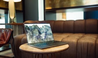 laptop with mountain background sitting on coffee table next to couch