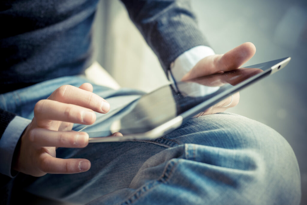 Person holding tablet monitor on lap