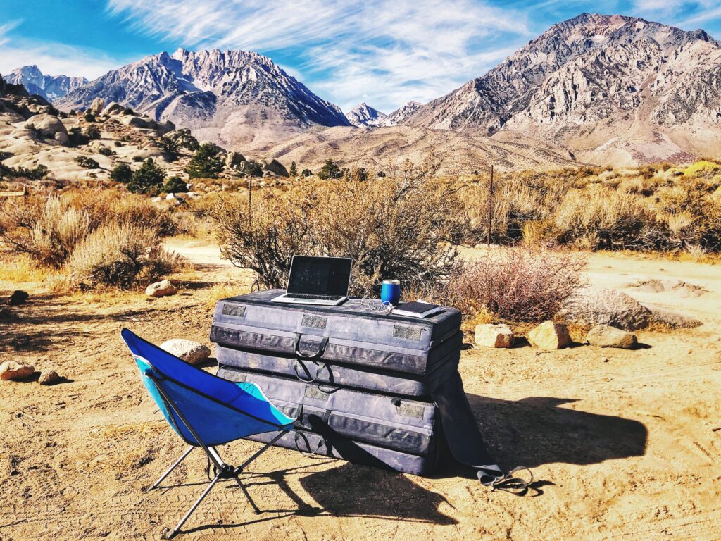 Remote work setup off a hiking trail surrounded by desert mountains