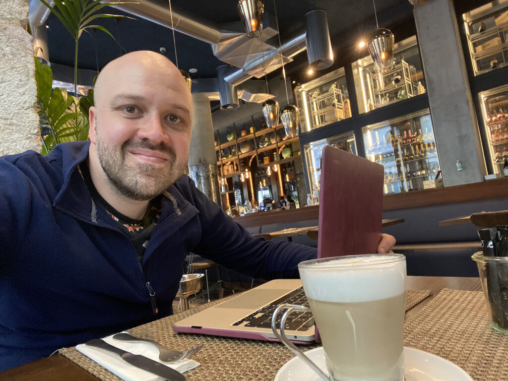 Man working remotely from a laptop in a Lisbon bar