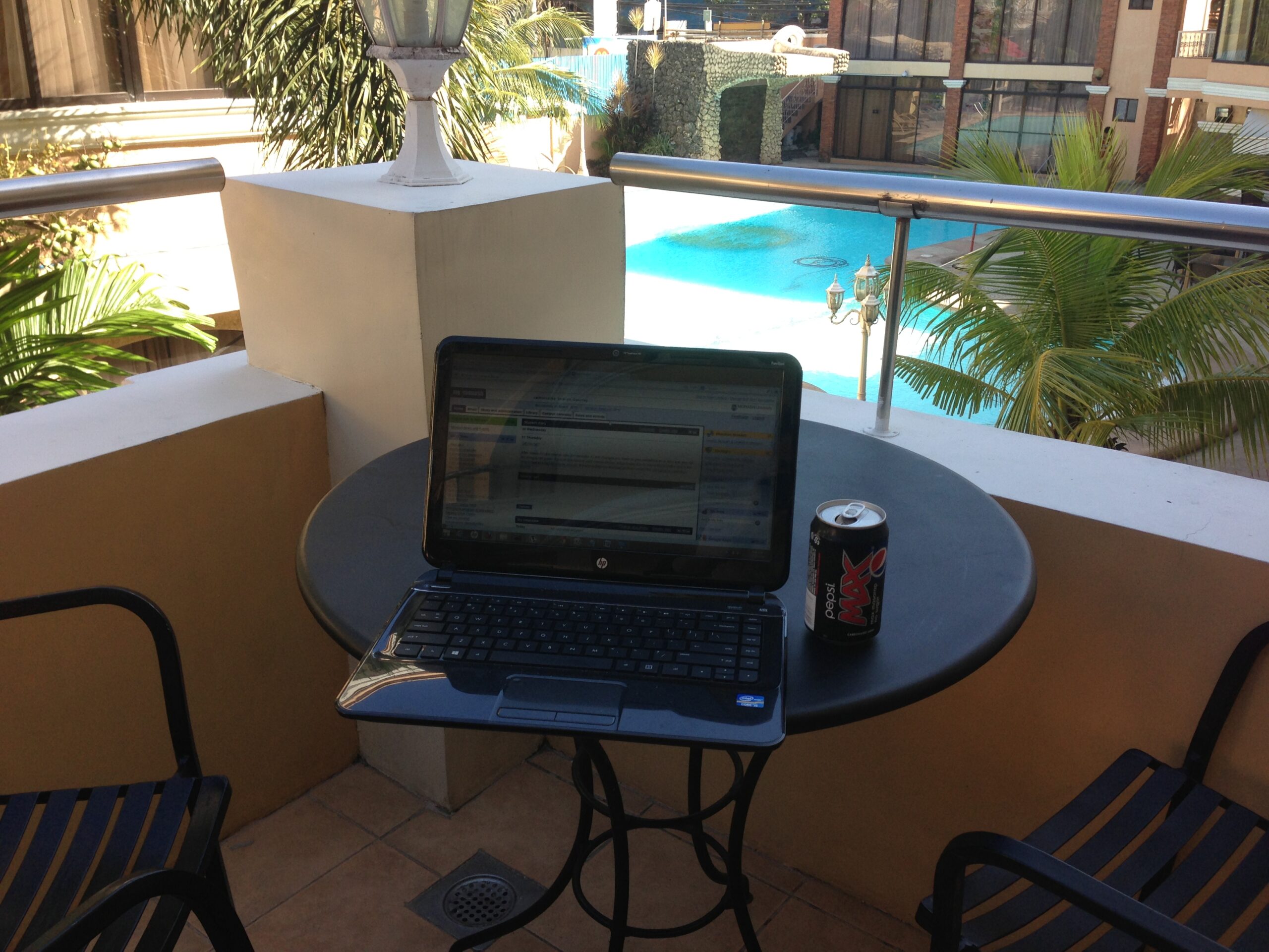 Remote work set up on balcony overlooking pool