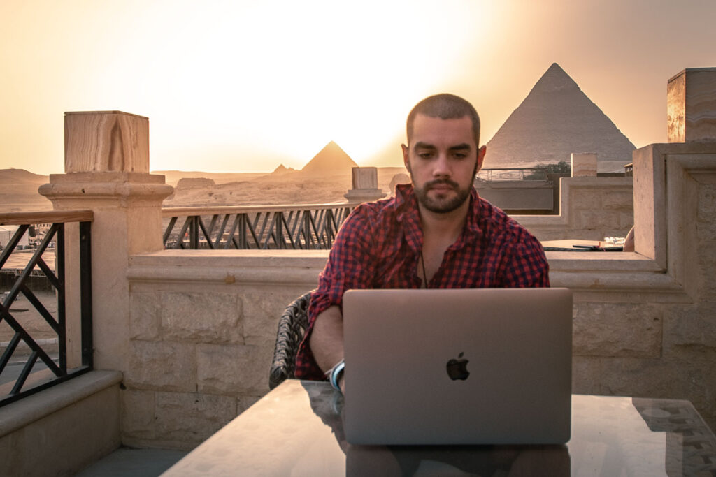 Man working remotely with view of pyramids behind him