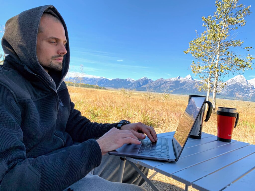 Man on laptop working with view of mountains in the background